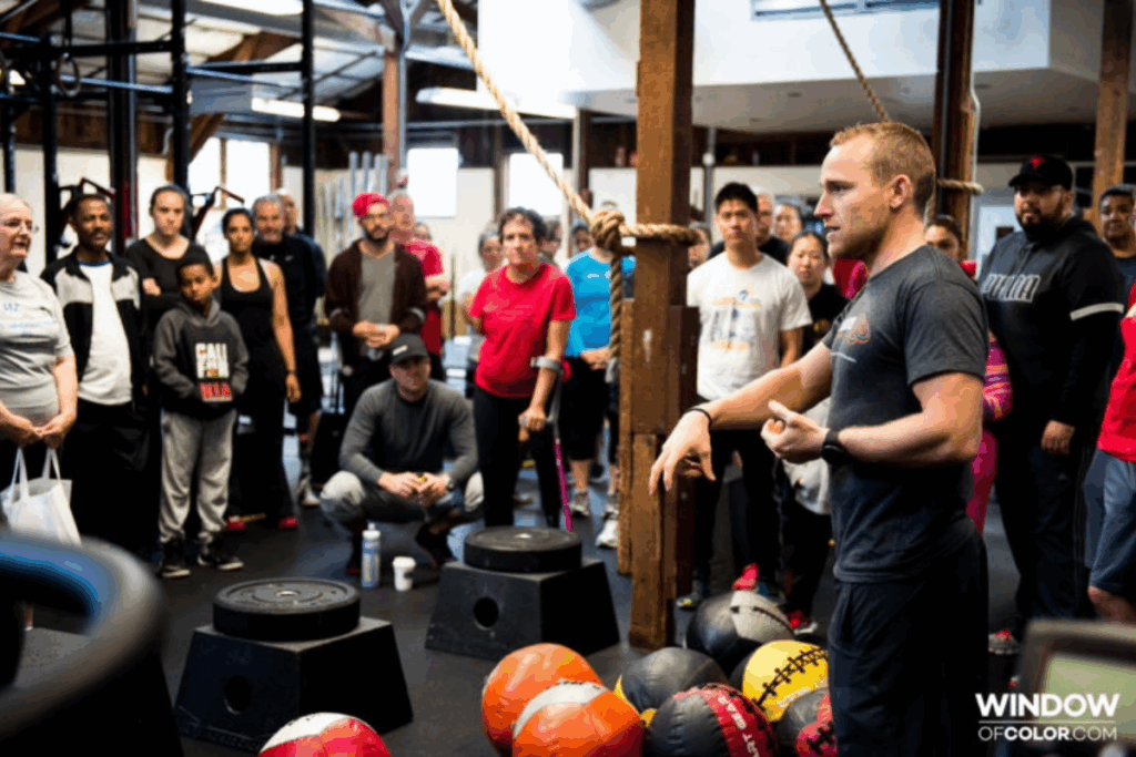 Adaptive CrossFit coach, Max Conserva, leading a large group of athletes and supporters during a training session.