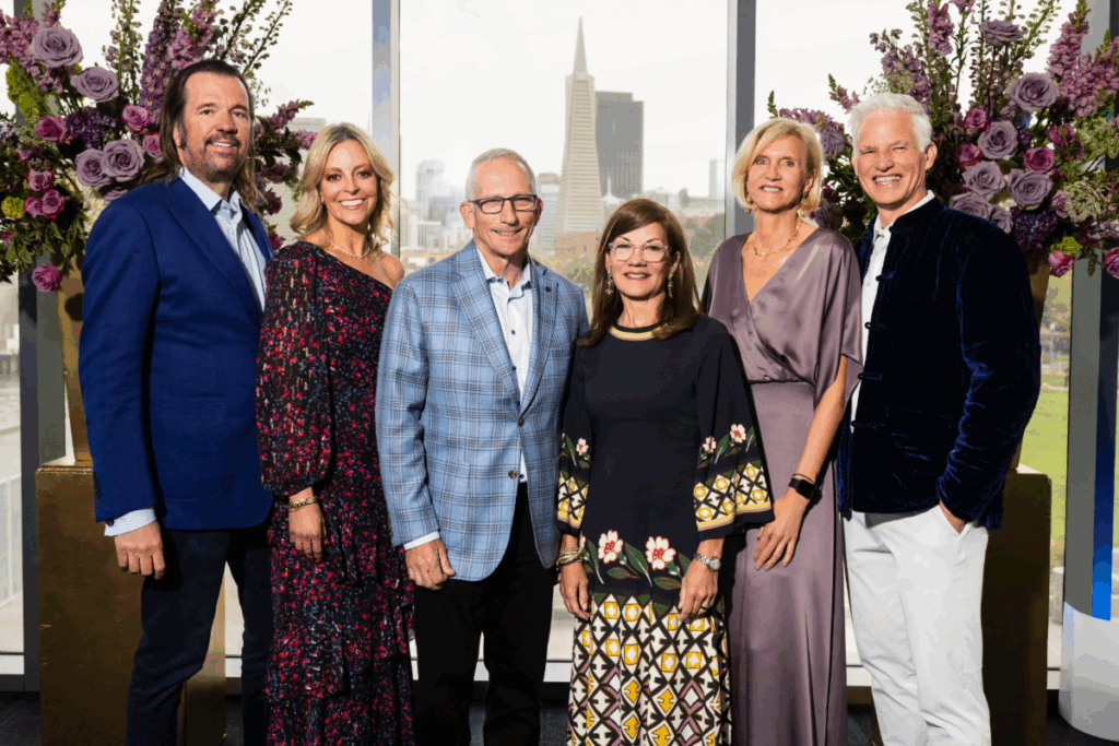 Group of Celebration of Heart chairs pose together in formal attire with the San Francisco skyline in the background.