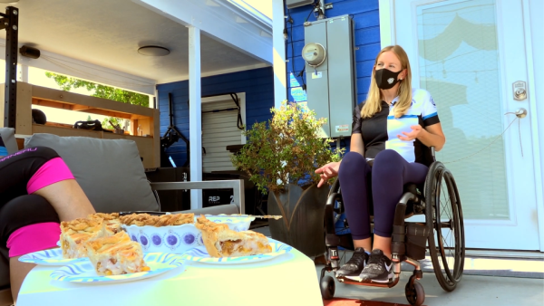 Two friends chat outdoors over slices of pie during Ride for Pie Day, building community through shared conversation.